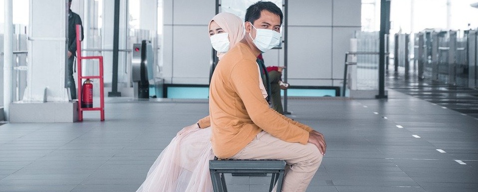 Two people sitting with masks on